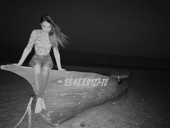Full length of woman sitting on boat at night