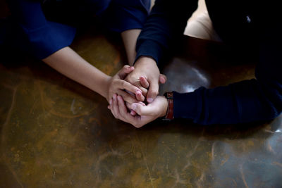 Midsection of couple holding hands