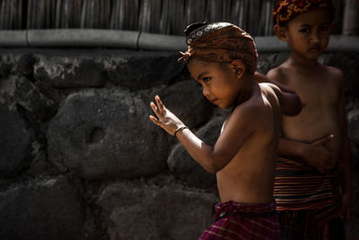 Portrait of child standing against wall