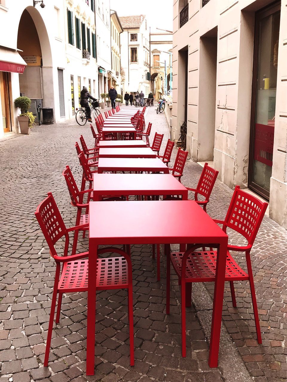 EMPTY CHAIRS AND TABLES ON STREET IN CITY