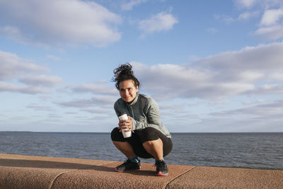 Girl squatting with bottle of water