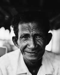 Close-up portrait of man smiling while sitting outdoors