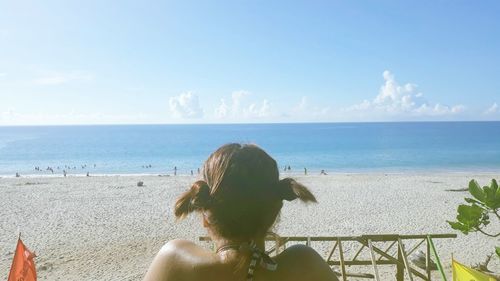 Rear view of woman looking at sea against sky