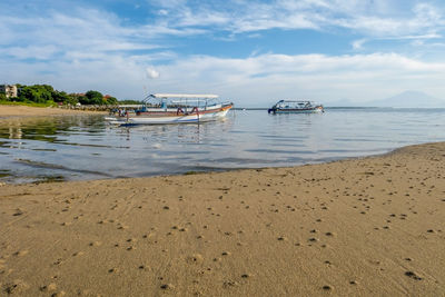 Boat moored on beach against sky