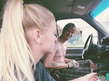 Portrait of happy brother sitting by sister in car