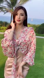 Portrait of smiling young woman standing against trees