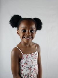 Portrait of a smiling girl standing against white background