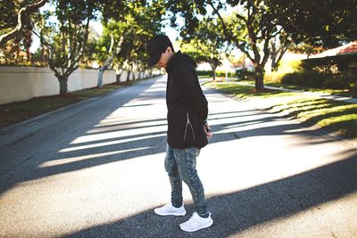 Rear view of man walking on road