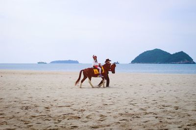 Girl horseback riding at beach