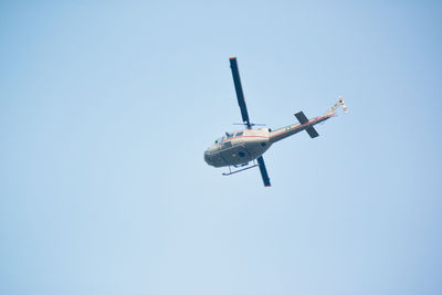 Low angle view of a helicopter against clear sky