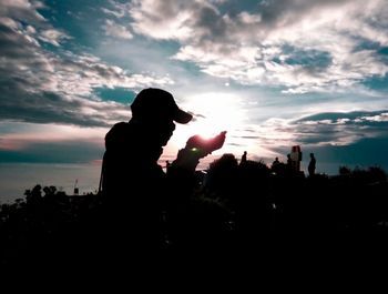 Silhouette people at against sky during sunset