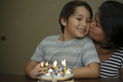 Close-up of mother kissing son during birthday