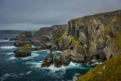 Rock formations by sea against sky