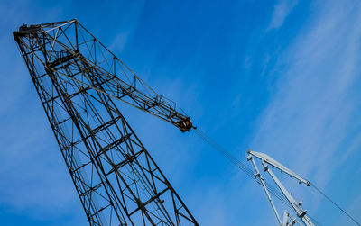 Low angle view of crane against blue sky