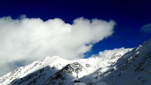 Low angle view of snowcapped mountains against sky