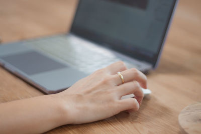 Midsection of man using laptop on table