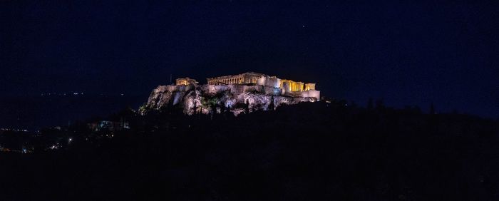 Illuminated buildings against sky at night