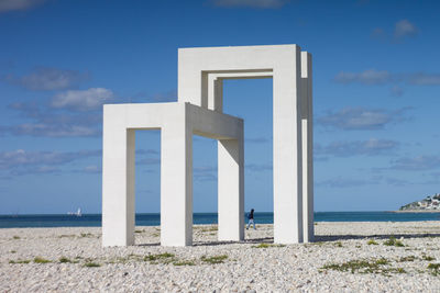 Pier on beach against sky