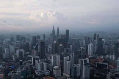 Aerial view of buildings in city against sky