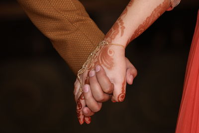 Cropped image of couple holding hands