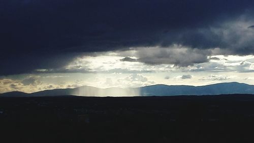 Scenic view of mountains against cloudy sky