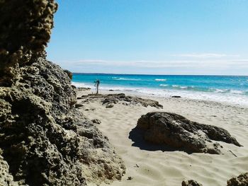 Scenic view of beach against clear blue sky