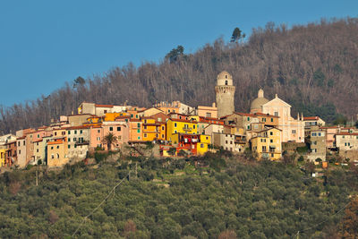 Houses and buildings against clear sky