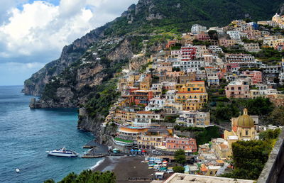 Aerial view of town by sea against sky