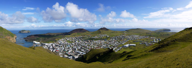 Panoramic view of town by sea against sky