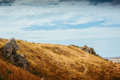 Scenic view of rocks by sea against sky