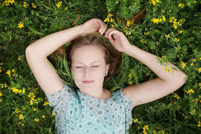 Directly above shot of young woman relaxing on field at park
