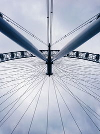 Low angle view of ferris wheel against cloudy sky