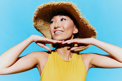 Portrait of young woman against blue sky