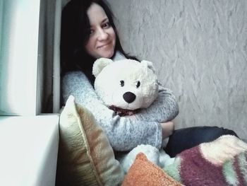 Portrait of young woman sitting on sofa at home