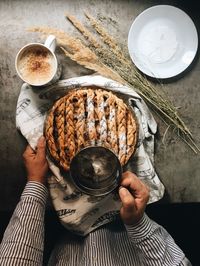 High angle view of woman holding coffee cup on table