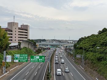 Road passing through city against sky