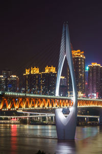 Bridge over river in city at night