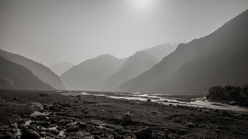 Scenic view of land and mountains against sky