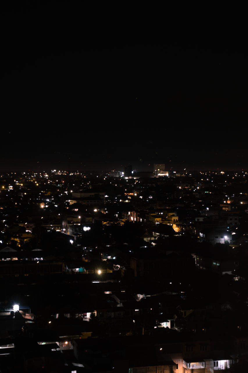 HIGH ANGLE VIEW OF ILLUMINATED BUILDINGS AT NIGHT