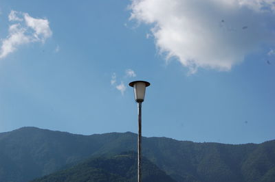 Low angle view of lamp post against mountains