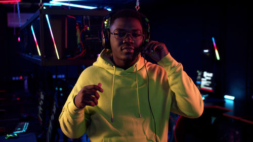 Portrait of young man standing in internet cafe