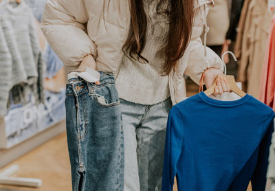 A young girl is shopping in a clothing store.