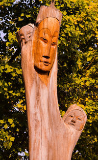 Low angle view of statue against tree trunk