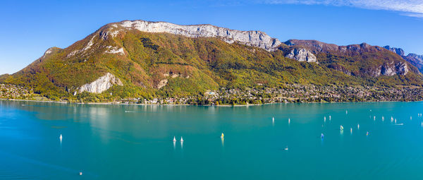 Scenic view of lake and mountains against blue sky