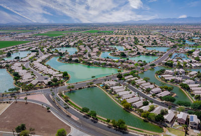 High angle view of city by river against sky