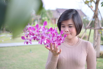 Portrait of woman against pink flowering plants