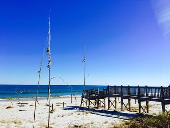 View of calm beach against clear blue sky