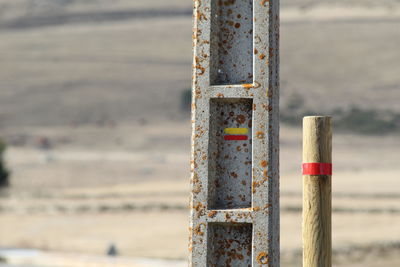 Close-up of rusty wooden post at beach