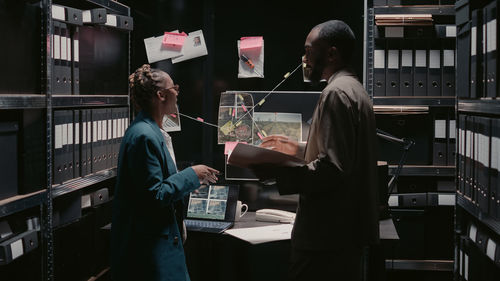 Rear view of man using laptop at table