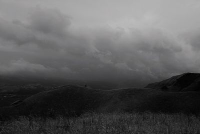 Scenic view of field against storm clouds